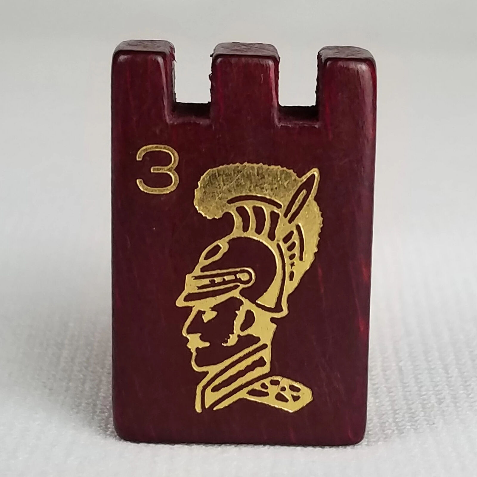 A game piece with a soldier's head and the number 3 on it.
